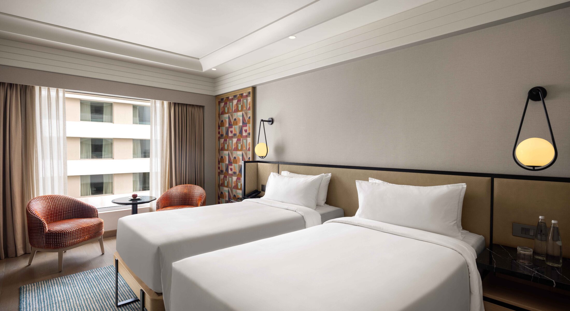 Superior Club Room featuring twin beds, contemporary décor, ambient lighting, and city views at Pullman Chennai Anna Salai Chennai